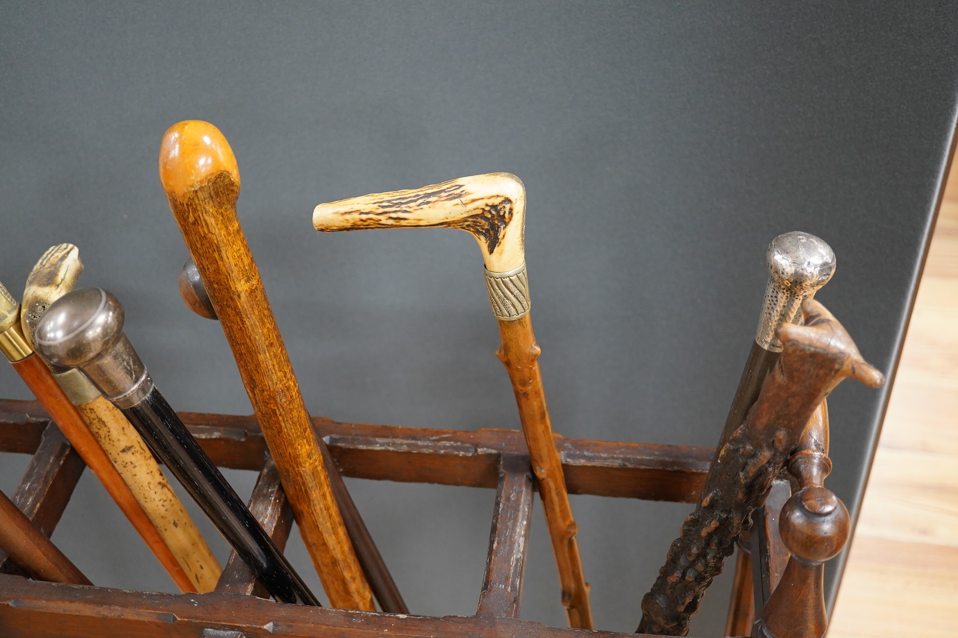 An Arts & Crafts oak umbrella stand and various walking sticks including two silver mounted. Condition - varies